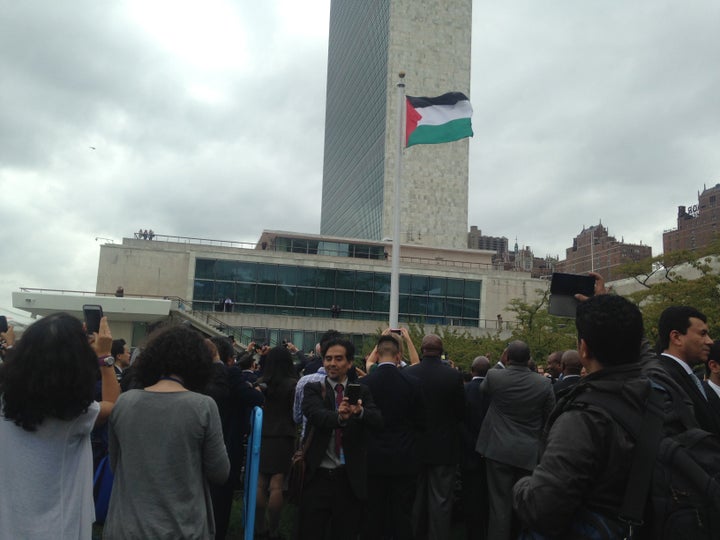 A man takes a selfie in front of the Palestinian flag after it was raised at the U.N. headquarters for the first time on Sept