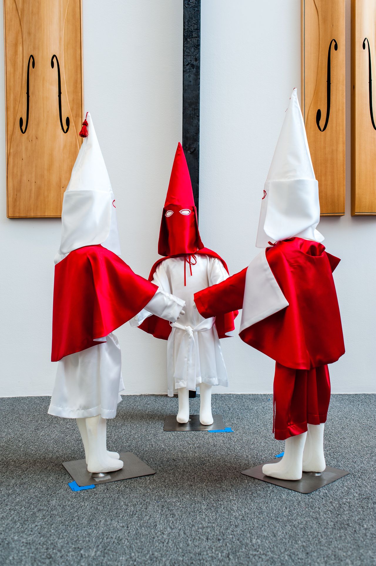 "Storm in a Time of Shelter," 2015: "For this piece, I re-imagined Ku Klux Klan robes from my memories of rallies growing up in the South. The centerpiece is a charred cross inscribed with hymns that were common in my childhood. Some of these were sung by the KKK, such as ‘The Old Rugged Cross.’ A well-known photo easily found online shows a toddler dressed in a Klan robe, face-to-face with a black state trooper. It made me ponder the learned aspects of fear, faith, hatred, and love."