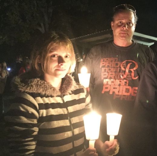 Taylor Johns, left, was with her father, Kristoffer, and her brother at a candlelit vigil in Roseburg, Orgeon, Thursday night.