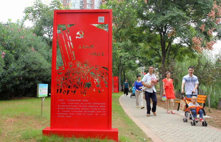 People walk past a statue of the Communist Party's "Three Rules of Discipline and Eight Points for Attention."