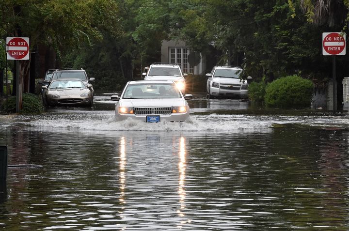 A car drives down a flooded street in Charleston, South Carolina, on Oct. 4, 2015.