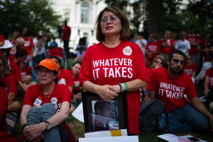 WASHINGTON, DC - SEPTEMBER 10: Maria Pike, 61, of Chicago, cries as she listens to a speaker during the event. She holds a ph