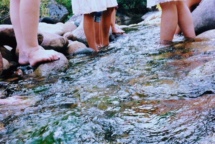 Participants wade through the Merced River at the Sweet Water Women's Retreat in August 2015.