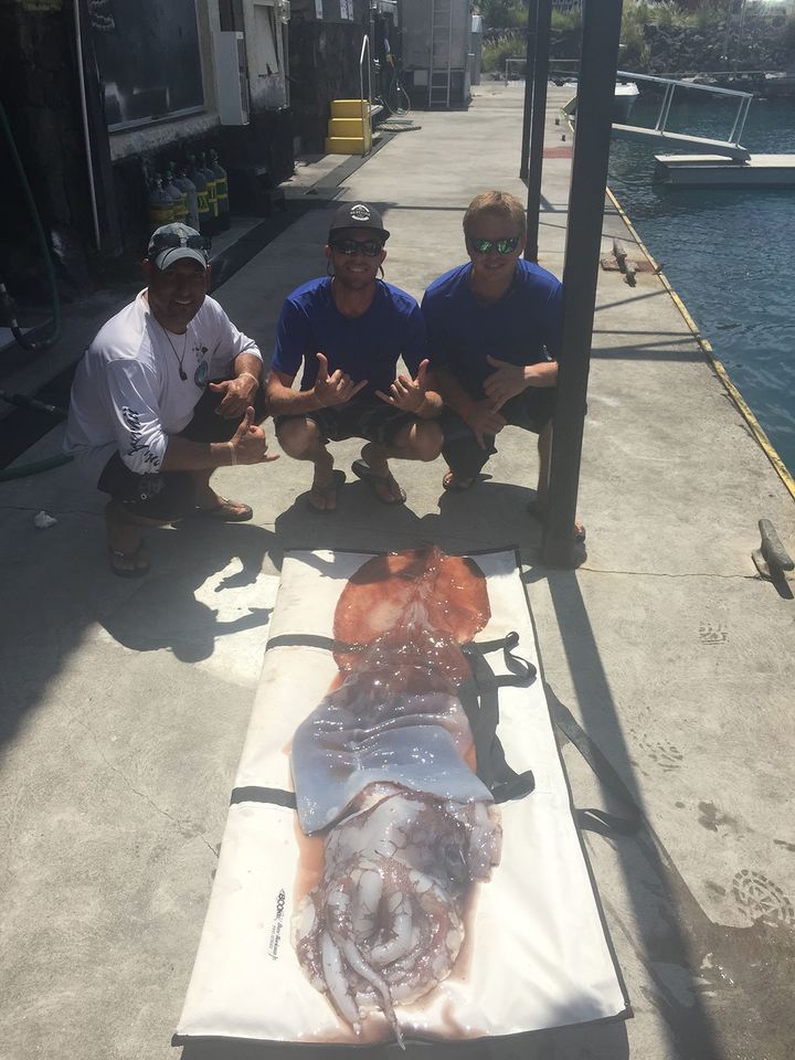 Manny Billegas II, Cyrus Widhalm and Ian MacKelvie are pictured with the dead squid.