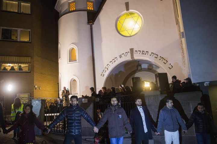 Norwegian Muslims create a human peace ring around the synagogue in Oslo, Norway on February 21, 2015. More than a 1,000 joined a peace vigil in Oslo Saturday, hosted by young Norwegian Muslims in a show of solidarity with Jews a week after fatal shootings in Denmark targeted a synagogue and free speech seminar. 