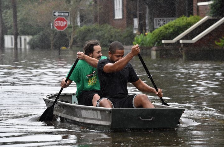 Two men row a boat on a flooded street in downtown Charleston, South Carolina on October 4, 2015.