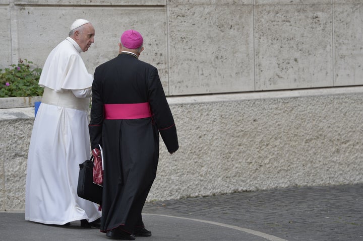 Pope Francis (L) leaves after the second morning session of the Synod of bishops on the Family at the Vatican on October 6, 2