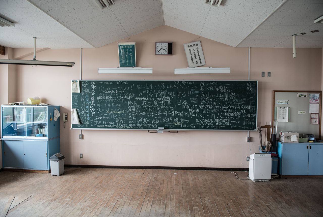 One of the classrooms on the first floor in a school. There is still a mark below the blackboard showing the level of the tsunami wave. On the blackboard in the classroom are words written by former residents, schoolchildren and workers in an attempt to keep up the morale of all of the victims, including "We can do it, Fukushima!"