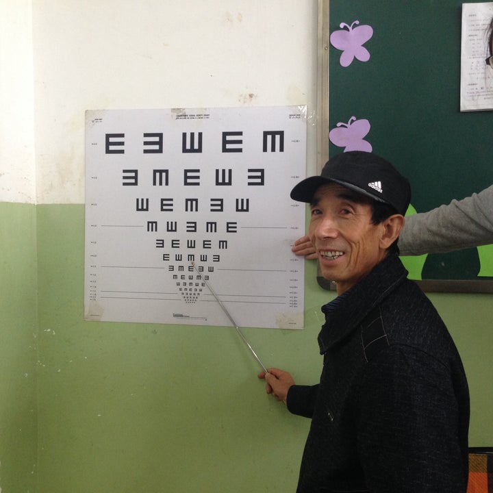 An elementary school teacher practices administering an eye exam during training.