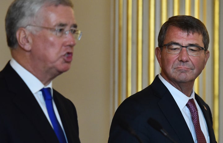 British Defence Secretary Michael Fallon (L) speaks as US Secretary of Defense Ashton Carter (R) listens at a joint press conference at Lancaster House in central London on October 9, 2015. The Pentagon-run programme to train and equip moderate Syrian rebels to fight Islamic State jihadists is being overhauled, U.S. officials said.