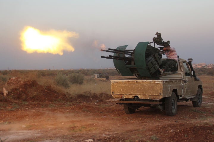 Rebel fighters fire a heavy machine gun during clashes with Syrian pro-government forces on the frontline facing Deir al-Zoghb, a government-held area in the northwestern Idlib province, on August 31, 2015.