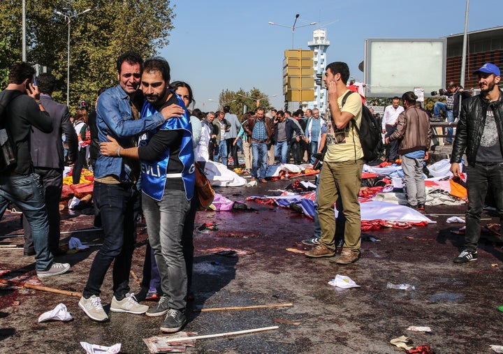 Survivors stand amongst the dead at the blast scene.