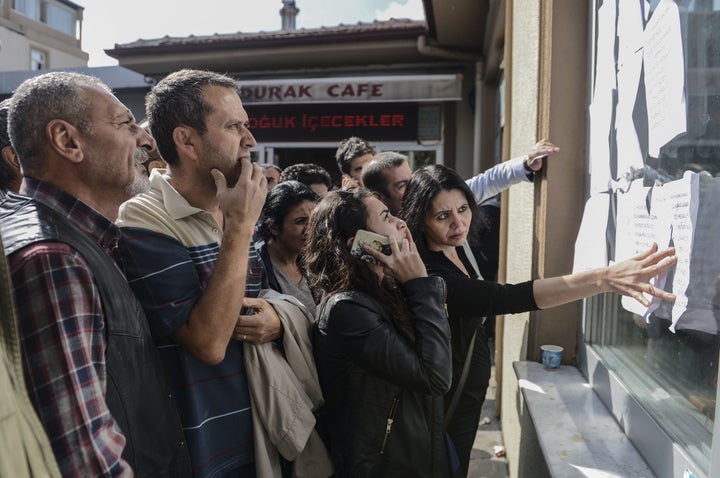 People check a list of the people who were injured in the blasts at the Ankara Numune hospital.