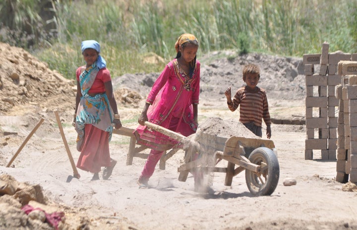 JAMMU, INDIA - 2015/06/11: An Indian girl, Kavita (12 years old), works along with her family at a brick kiln in outskirts of Jammu on the eve of The World Day against Child Labor, which is intended to foster the worldwide movement against child labor in any of its forms. (Photo by Pacific Press/LightRocket via Getty Images)