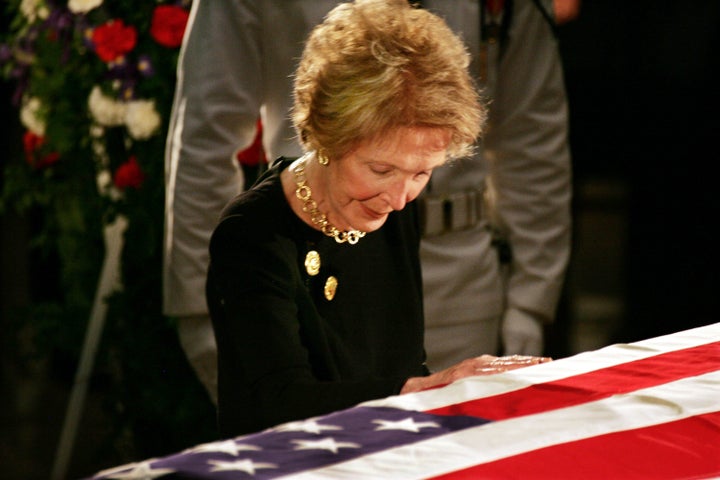 Nancy Reagan touches her husband's casket as he lies in state inside the rotunda of the U.S. Capitol on June 9, 2004.