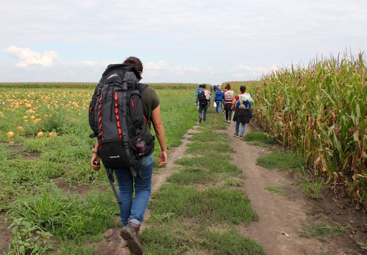 Hiba Dlewati walks with a group of Syrian men, women and children from war-torn Kobani as they trek to the Serbia-Hungary border after hours of walking in the baking sun. They carry as little as possible: documents, cash, food, water and sleeping bags.