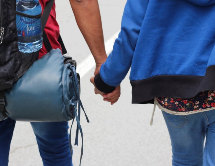 Dozkin and Serwan hold hands as they walk toward the Serbia-Hungary border on Aug. 23. They have a long walk ahead of them, following train tracks, walking through farm fields and eventually digging under the razor-sharp border fence that seals off Hungary.