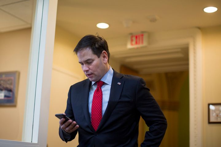 Sen. Marco Rubio (R-Fla.) checks his smartphone while walking through the Senate Radio, TV Gallery.