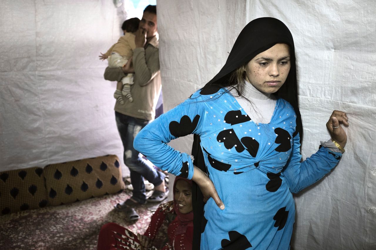 Syrian refugee Hened Al Ahmad, 14, stands inside a tent shelter in Rawda, Bekaa Valley. Hened, who got married 18 months ago, is now a widow. Her husband died six months after they wed in their homeland. Pregnant at the time, she later miscarried -- due, she said, to the pain and fear she felt.