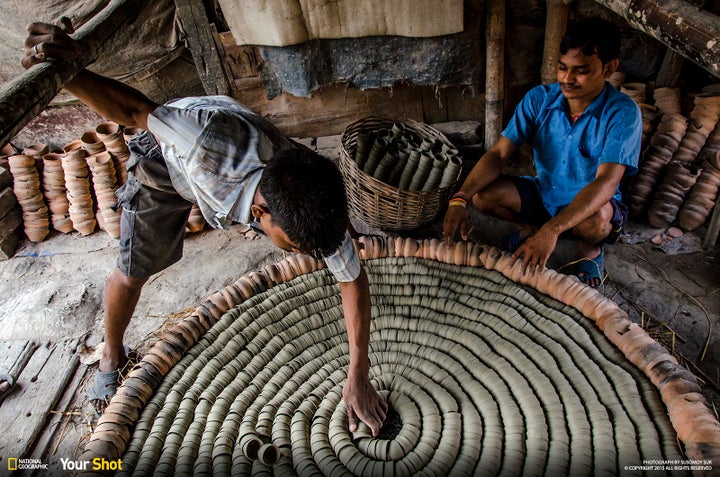 In "Soil," men arrange clay cups to form disposable chai tea vessels in India.