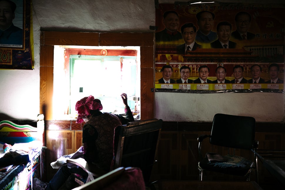 A woman sews by the light of a window in Wenping village.