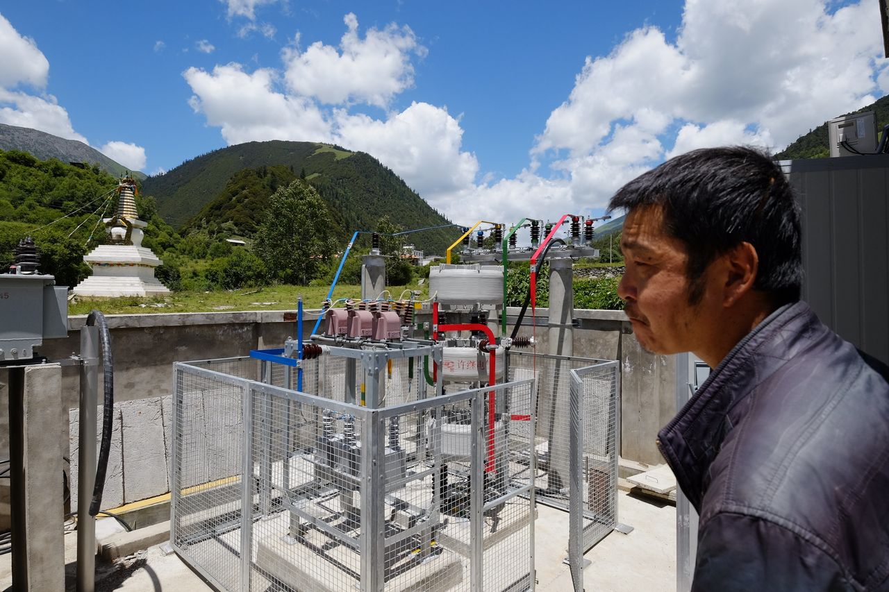 A employee of the power company surveys the new power station near Er Dao Qiao village.