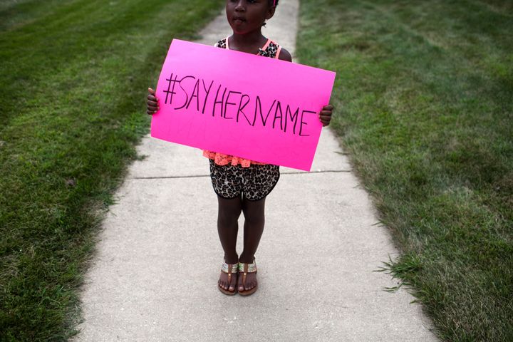 Daija Belcher, 5, holds a #SayHerName sign during the funeral service for Sandra Bland on July 25, 2015 in Lisle, Illinois. (Photo by Jonathan Gibby/Getty Images)