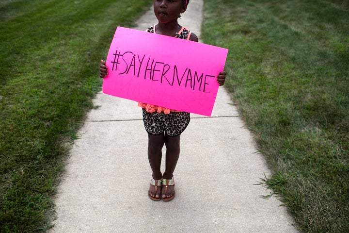 Daija Belcher, 5, holds a #SayHerName sign during the funeral service for Sandra Bland on July 25, 2015 in Lisle, Illinois. (Photo by Jonathan Gibby/Getty Images)