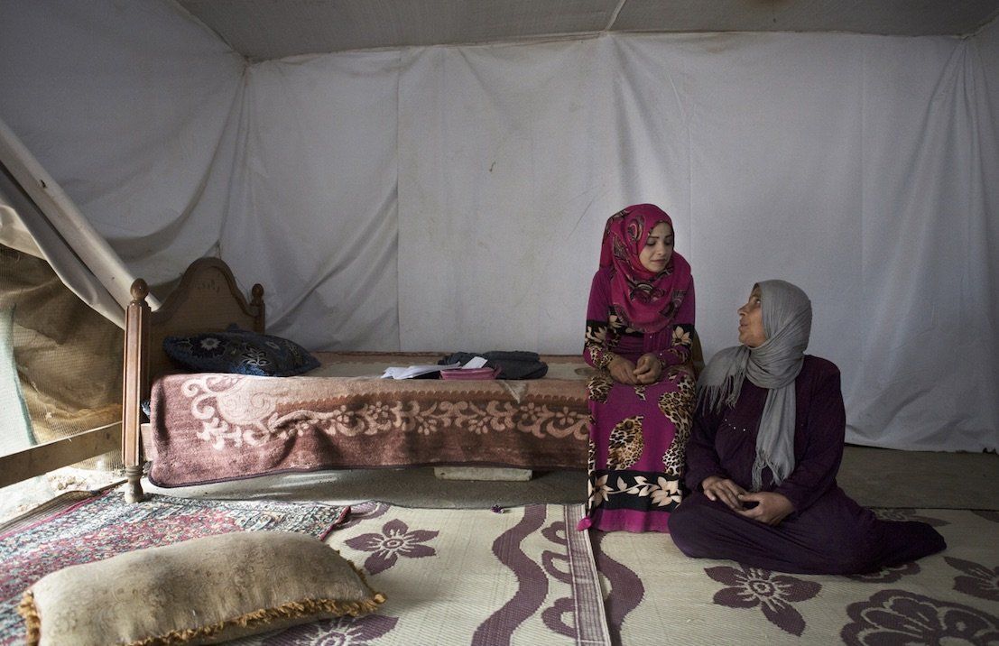 Sumayya, 14, sits with her mother inside their tent shelter in Jeb Janine, Bekaa Valley. The adolescent refused to get married, and her mother decided not to force her.