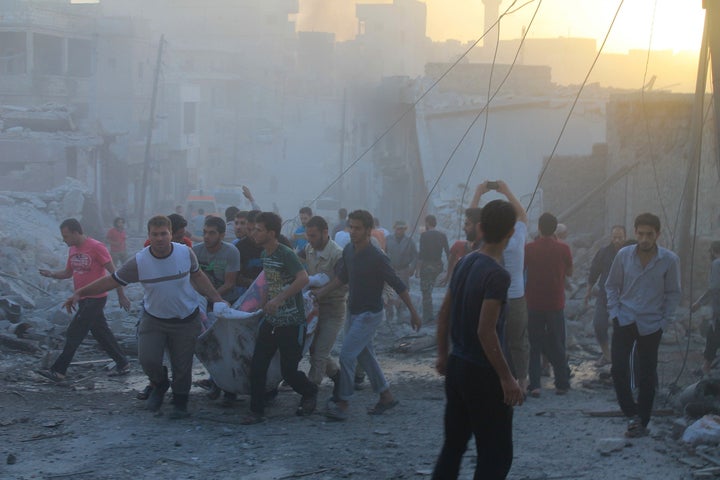 People carry casualties after a reported Russian airstrike in the town Daret Ezza in Aleppo on Oct. 13, 2015.