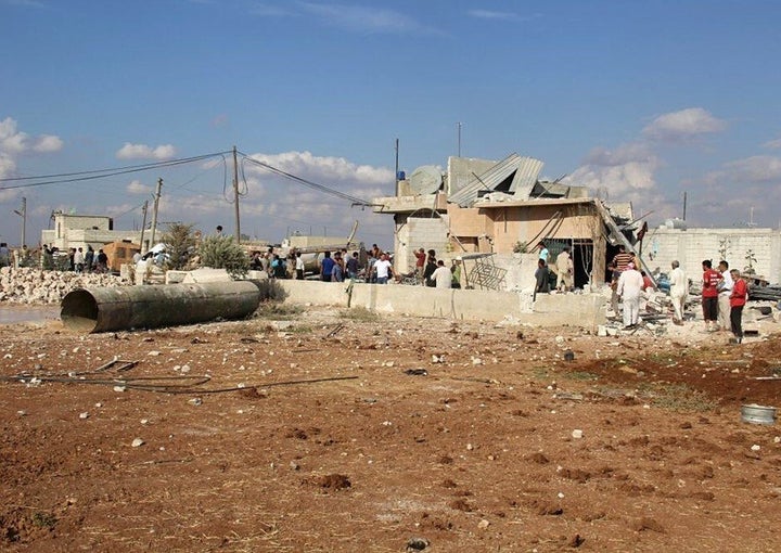 Residents gather outside the destroyed buildings reportedly damaged by Russian airstrikes in Maasaran, Syria, on Oct. 7, 2015.