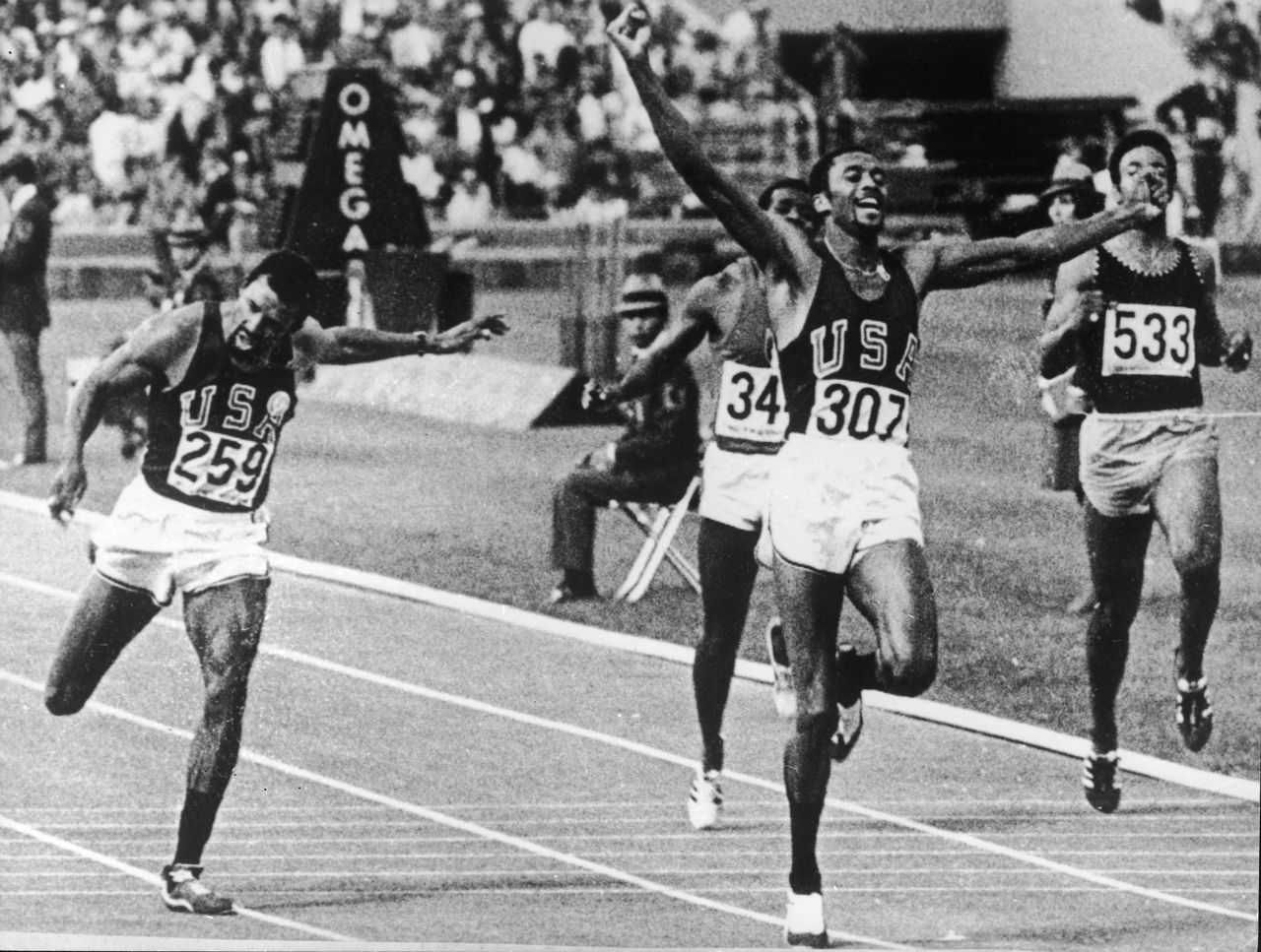 Tommie Smith raises his arms as he crosses the finish line to set a new world and Olympic record at the 1968 Summer Olympics in Mexico City, Oct. 16, 1968.