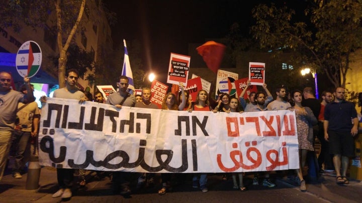 Israeli and Palestinian activists hold a banner that says "Stopping Racism" in Hebrew and Arabic. Some 2,000 people demonstrated for peace in Jerusalem on Saturday, Oct. 17.