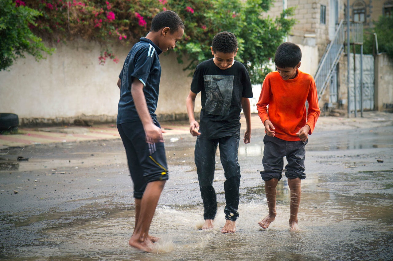 Children enjoy a downpour on Aug. 11, 2015.