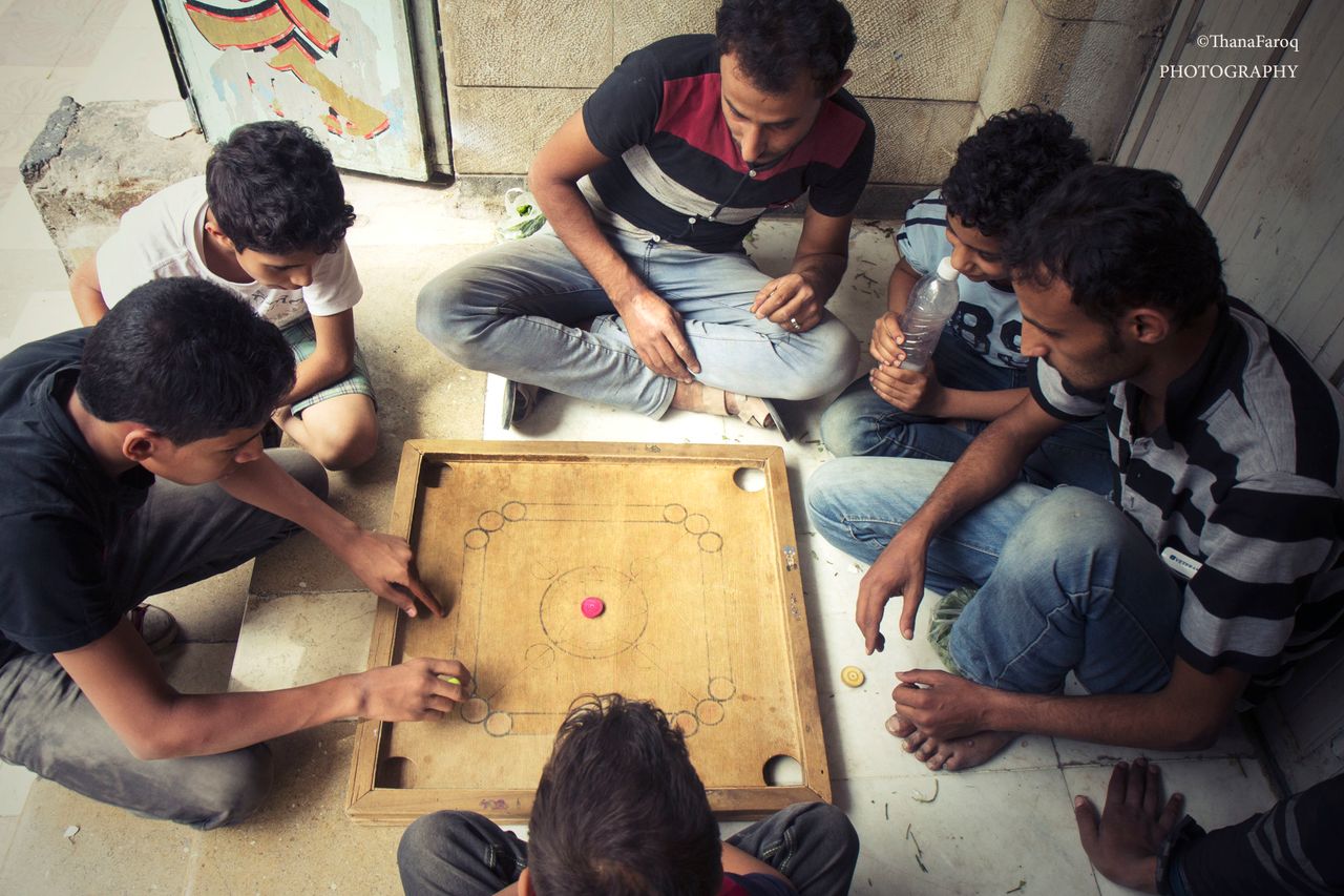 Young people play a game on Jamal Street in Sanaa on June 15, 2015.