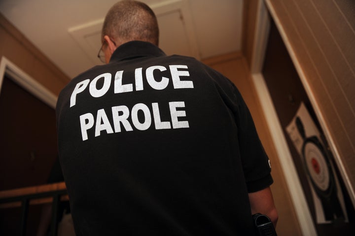 Parole Officer Ryan Burch gets ready to knock on the apartment door of a parole where he is making a non-scheduled home visit in Englewood, CO.