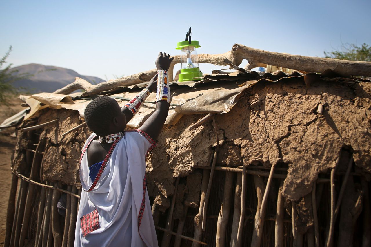 A Maasai woman sets up a solar light to recharge in the village of Koora, Kenya.