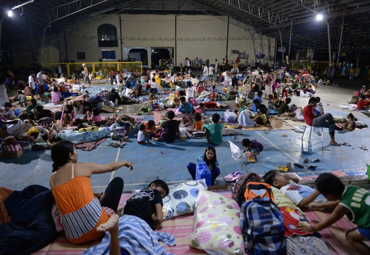 People evacuated from their homes rest inside a makeshift shelter in a school in Cabanatuan City, Philippines, on Oct. 19, 20