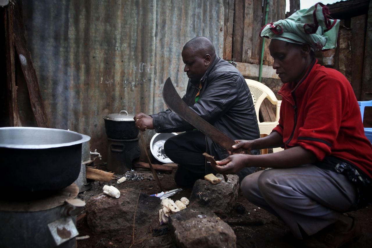 Keneth Ndua and his sister Jane Muthoni use a cookstove in Ngawa, Kenya, Saturday, Aug. 8, 2015.