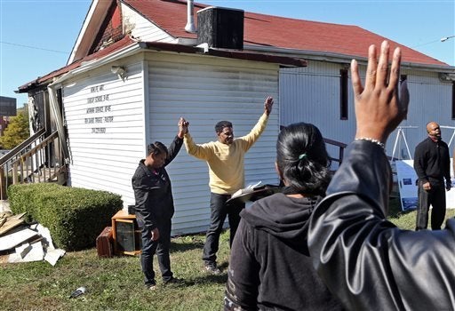 In this Sunday, Oct. 18, 2015 photo, Pastor David Triggs and his wife, Charronda, hold hands and take part in the outdoor ser
