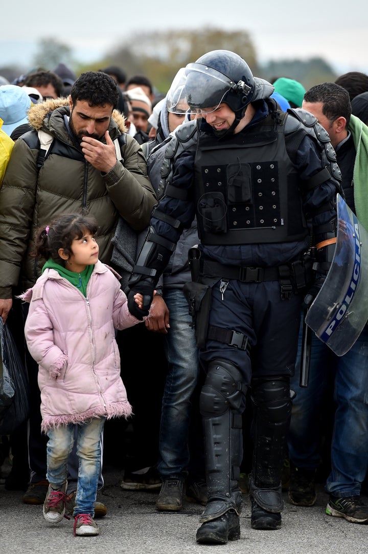 Refugees and migrants are escorted by police through Dobova as they are walked holding camp on October 22, 2015 in Dobova, Slovenia.