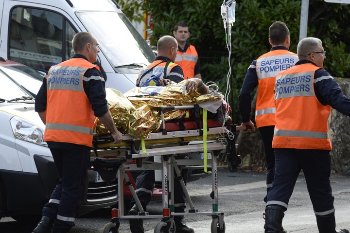 Emergency personnel rush an injured person to safety following the fatal collision.