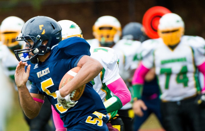 Israel Squires (5) rushes in a 2014 game for Shoreham Wading River High School in New York the week after his teammate Tom Cutinella died on the field.