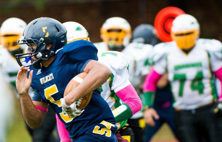 Israel Squires (5) rushes in a 2014 game for Shoreham Wading River High School in New York the week after his teammate Tom Cutinella died on the field. 