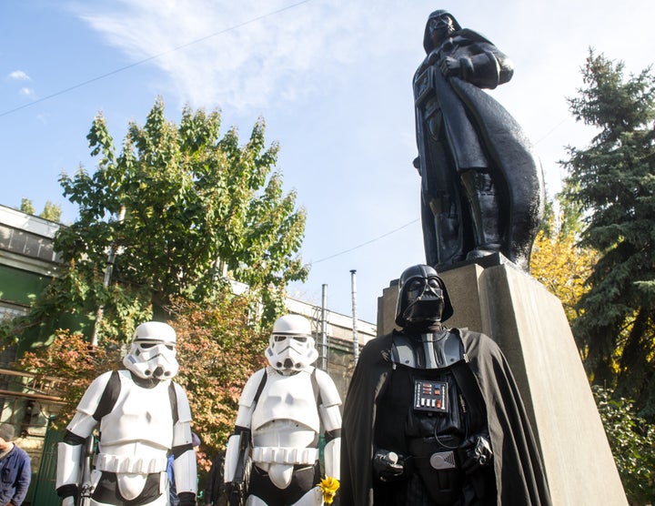 Costumed Storm Troopers and Darth Vader take in the unveiling of the converted statue.