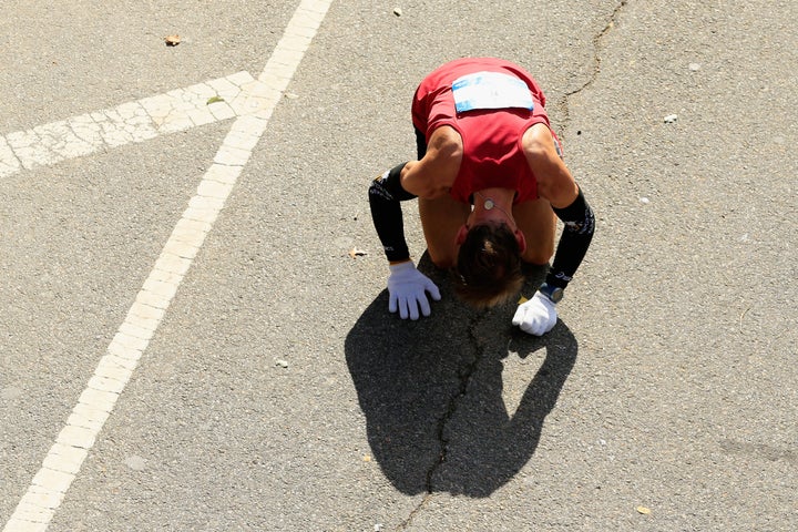 A participant reacts after crossing the finish line in Central Park during the 2014 TCS New York City Marathon.