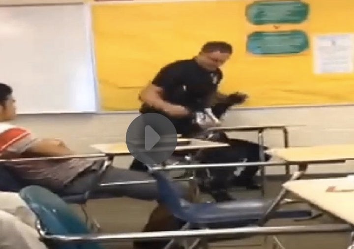 An officer pulls a student from her desk at Spring Valley High School in South Carolina. 