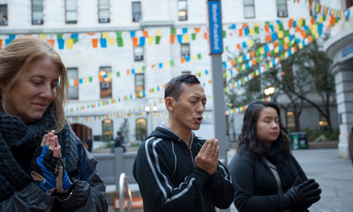 People pray at Philadelphia's City Hall, where homemade flags are on display in honor of the Day of Kindness.