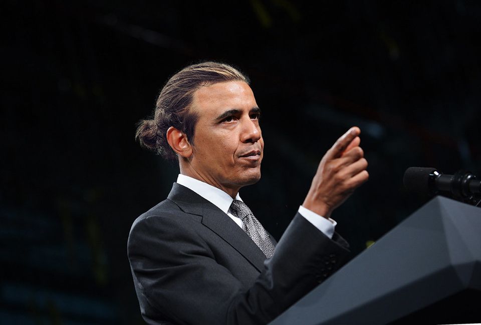 Barack Obama wears a slicked-back man bun.