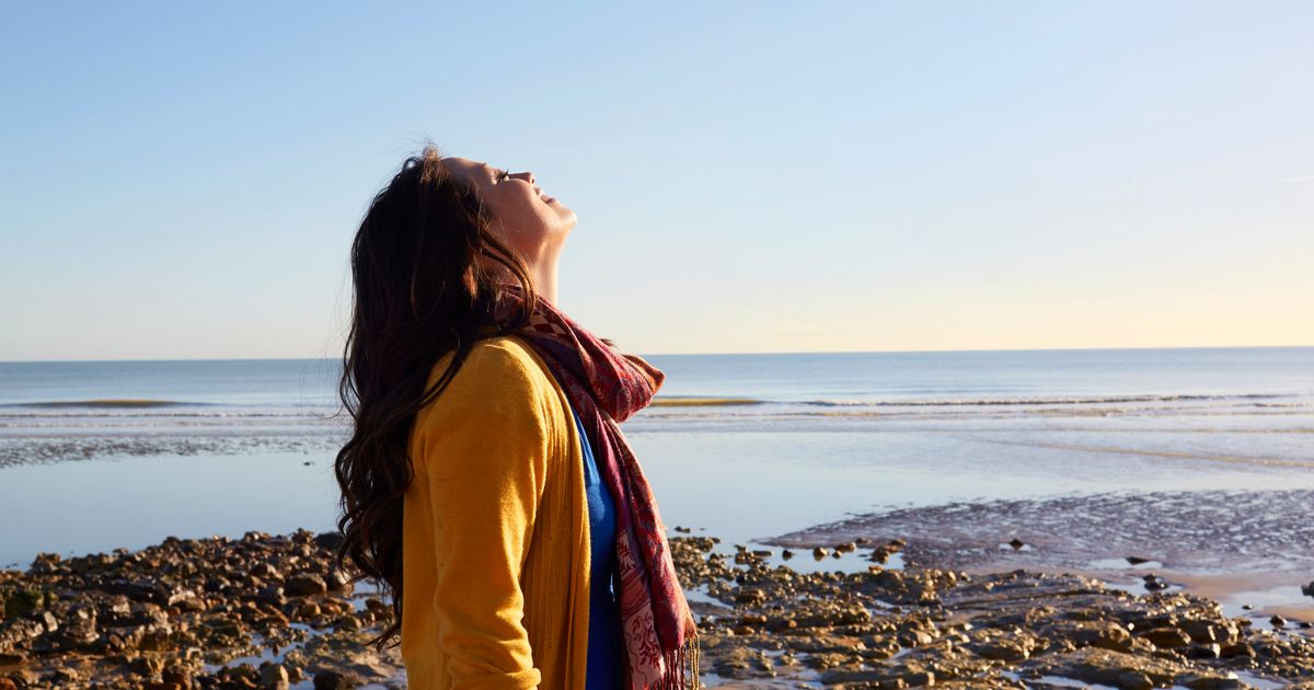 Most people know. Walking in the Fresh Air. The Psychology of gratitude. Photo of woman on the Beach from very far away.